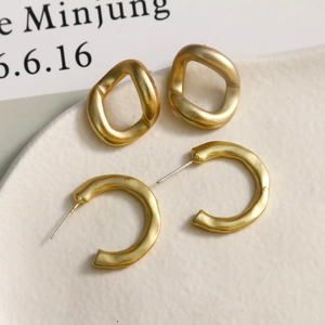 Minimalist matte gold S925 silver needle C-shaped earrings and irregular hoops on a ceramic tray