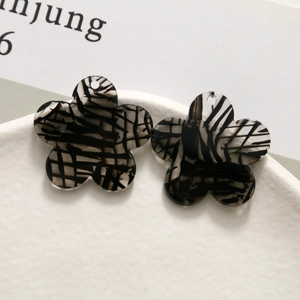 Close-up of ink-patterned acetate plum flower charms with pre-drilled hanging holes