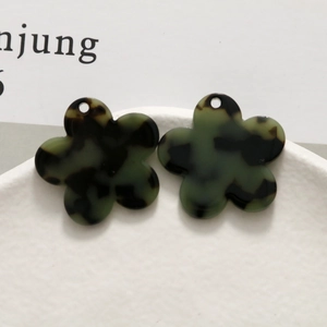 Macro shot of dark green tortoiseshell flower charms for DIY handmade earring accessories