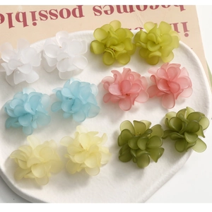 Matte acrylic flower earrings set in six pastel colors on white textured tray