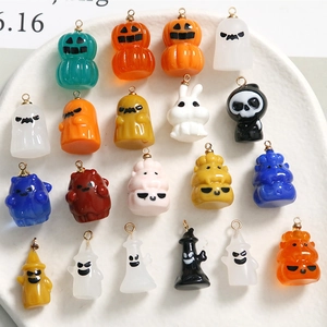 Makroansicht verschiedener Halloween-Resin-Anhänger mit Kürbissen und Geistern in Keramikschale