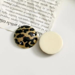 Detail of round leopard print and cream resin cabochons for DIY jewelry and hair clips