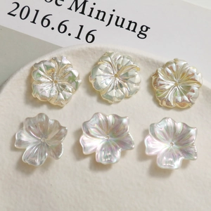 Detailed view of six iridescent pearlized flower beads for DIY jewelry making