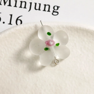 Macro shot of matte white frosted flower bead with pink core and silver pendant ring