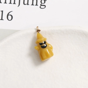 Makroaufnahme großer gelber Halloween Kürbis Geist Harz Anhänger mit goldenem Metallring