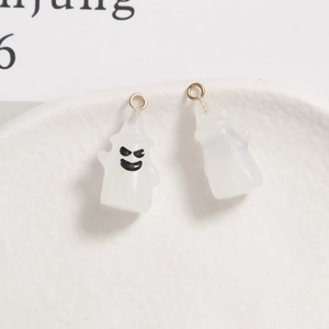 Detail von zwei durchscheinenden Geisteranhängern aus Harz mit goldenen Ösen für DIY-Schmuck