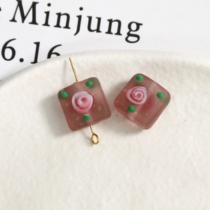 Detail of square glass flower bead with pink rose and golden pin for DIY jewelry making