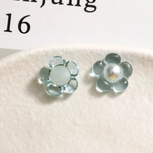 Vue macro de pétales de fleurs en résine bleu clair avec centre en perles sur plateau