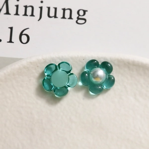 Vue macro de breloques fleurs en résine bleue avec perle pour création de bijoux