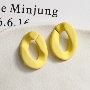 Vue macro de breloques ovales torsadées en résine jaune mat pour boucles d'oreilles DIY