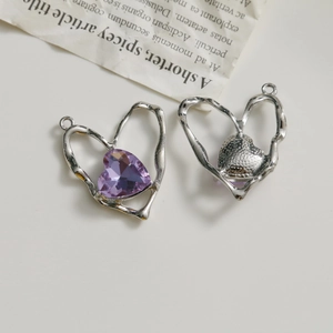 Détail macro de pendentifs cœur en alliage argenté avec cristaux violets et texture métal