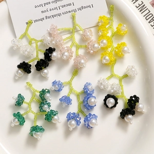 Boucles d'oreilles artisanales en perles muguet en six couleurs sur un plateau de porcelaine