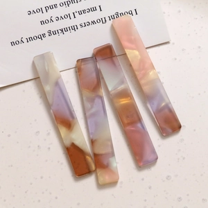 Primer plano de cuatro pinzas para el cabello rectangulares de acetato aurora con textura de mármol