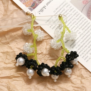 Vue détaillée des boucles d'oreilles en perles avec cristaux verts facettés et perles