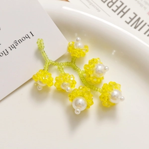 Détails de boucles d'oreilles fleuries faites main avec perles jaunes et blanches