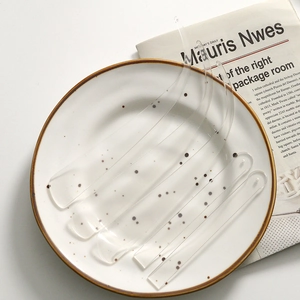 Minimalist clear acrylic irregular strip pendants set on a decorative plate