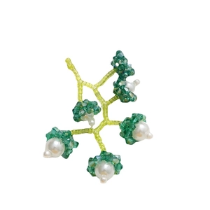 Boucles d'oreilles féeriques faites à la main avec perles et cristaux verts sur fond blanc