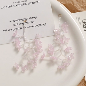 Macro shot of light pink bellflower glass beads for DIY earrings in a white tray