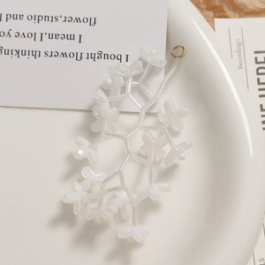 Macro shot of white translucent bellflower beads with gold loop for DIY jewelry