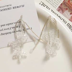 Gros plan détaillé de longues boucles d'oreilles à pompons en perles de verre