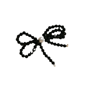 Beaded bow accessory with black faceted crystals and a large white pearl center