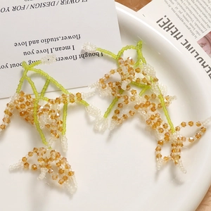 Detailed view of handmade beaded lily of the valley earrings with crystal flower clusters
