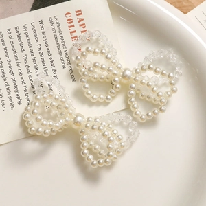 Élégant ensemble de deux barrettes à nœuds en perles nacrées et acrylique sur plat céramique