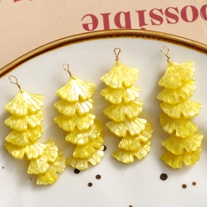 Close-up of yellow resin ginkgo leaf pendants with sparkling gold dust for jewelry DIY