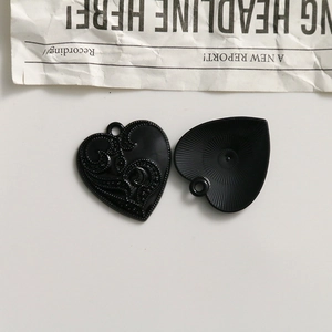 Detailed macro view of heart-shaped gothic alloy charms with relief and sunburst textures