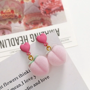 Detailed view of pink plush peach drop earrings with heart studs and leaf accents