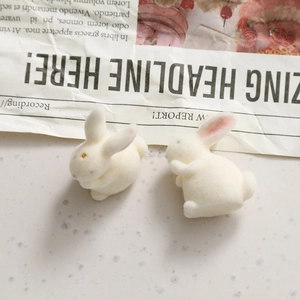 Detail of white flocked rabbit charms showing soft texture and pink ear accents