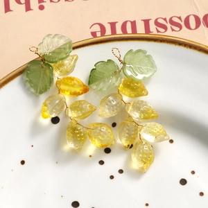 Primer plano detallado del colgante de limón con dije de hoja verde en un plato de cerámica