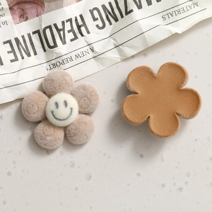 Dettaglio di ciondoli in resina a forma di fiore floccato beige con smiley per bijoux DIY