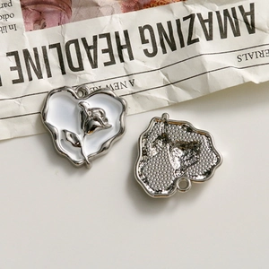 Macro detail of heart-shaped rose pendant charms with white enamel and silver relief
