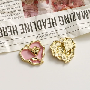 Detail of pink heart charms with gold rose relief showing front and back textures