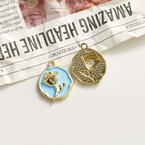 Detailed macro view of vintage rose charms in gold and blue enamel for DIY jewelry making