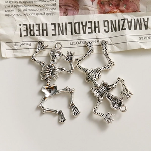 Detailed front and back view of silver skull alloy charms for DIY punk jewelry making