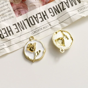Macro view of gold-plated rose charm with white enamel and textured back for DIY jewelry