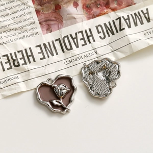 Macro view of vintage heart rose pendants with enamel inlay and silver-plated finish