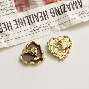 Macro detail of heart-shaped rose pendants with vintage brown oil drip finish and gold relief