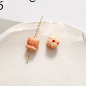 Makro-Detail von Maiglöckchen-Perlen in Korallenrosa für DIY-Schmuckherstellung