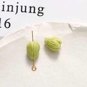 Macro view of light green flower bud beads with gold metal loop pins for DIY jewelry