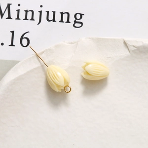 Detailed view of cream tulip resin beads for DIY jewelry making on white stone