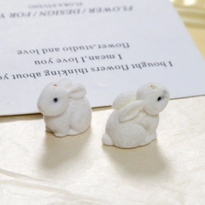 Close-up of cute white flocked rabbit resin charms with soft velvet texture for DIY
