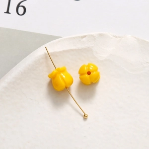 Detail von glänzenden gelben Tulpen-Harzperlen mit Goldstift für DIY-Schmuckherstellung