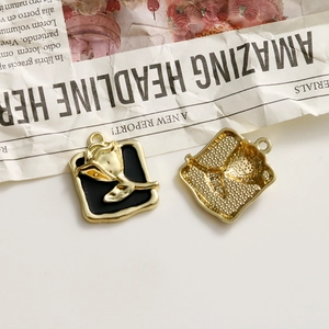 Detail of square gold tulip pendants with black enamel and honeycomb texture back