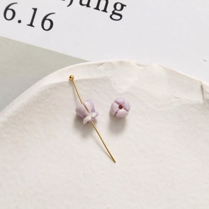 Nahaufnahme der 6mm lavendelfarbenen Maiglöckchen-Perle mit goldener T-Stift-Halterung