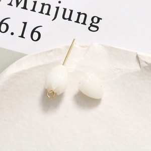 Macro shot of white tulip resin beads for DIY jewelry on artistic stone background