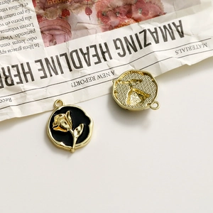 Detail of vintage round rose charms with gold plating and black enamel for DIY jewelry