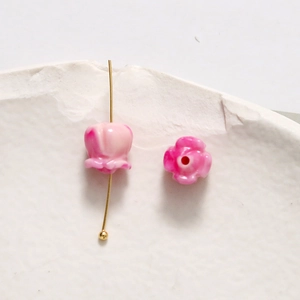 Makro-Detail von Maiglöckchen-Perlen mit rosa Farbverlauf und Loch für DIY-Schmuck